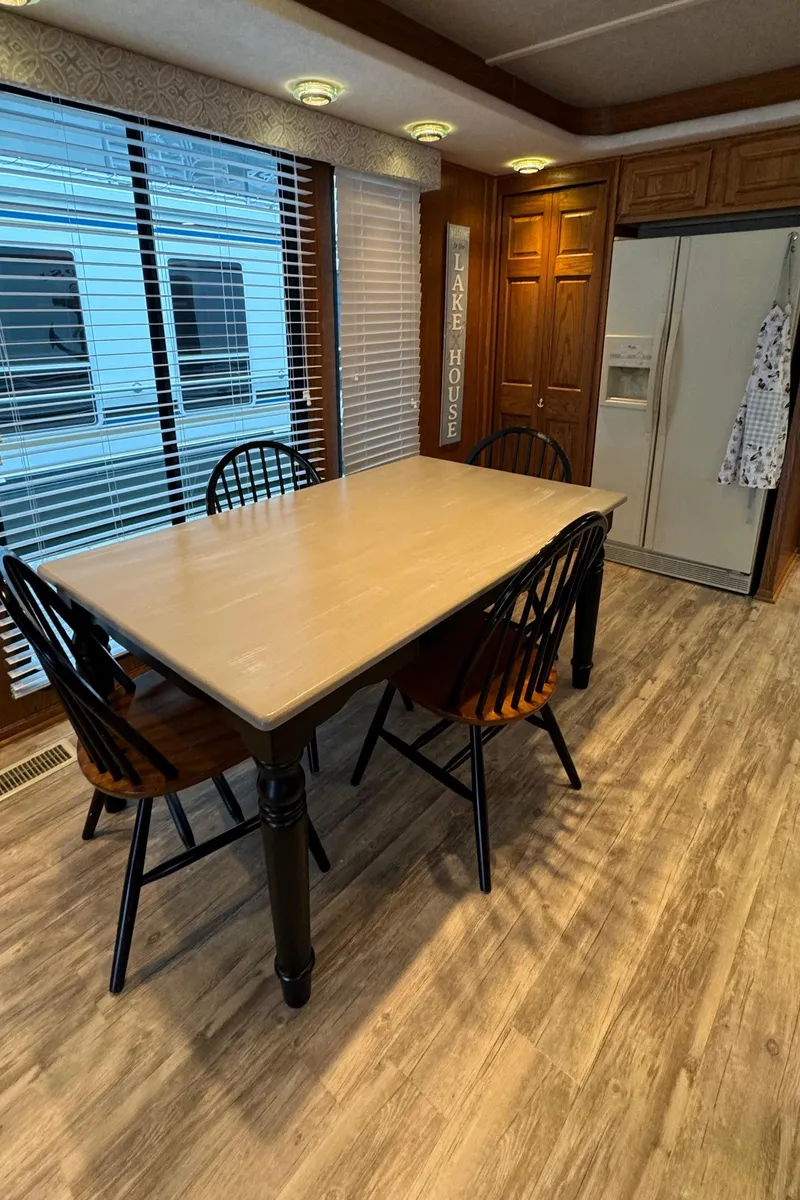 Slide: The Image of Dining area in a 1999 Sumerset 16 X 80 houseboat with wooden table and chairs. - 27