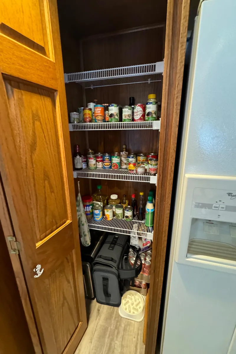 Slide: The Image of Pantry with organized shelves of condiments and canned goods in a Sumerset 16 X 80 houseboat. - 32