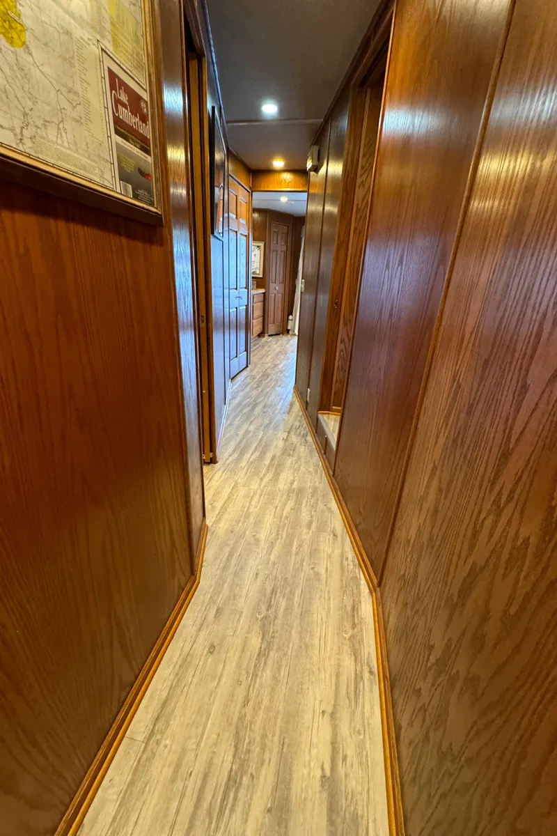 Slide: The Image of Narrow hallway in 1999 Sumerset 16 X 80 houseboat with wooden paneling and flooring. - 33