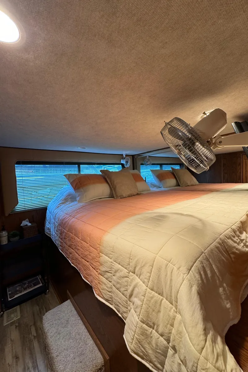 Slide: The Image of Cozy bedroom interior in a 1999 Sumerset 16 X 80 houseboat with a neatly made bed. - 36