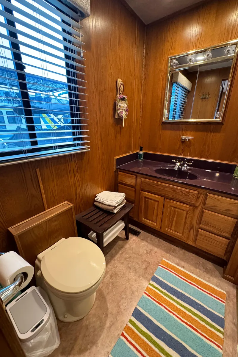 Slide: The Image of Bathroom in 1999 Sumerset 16 X 80 houseboat with wood paneling and striped rug. - 43