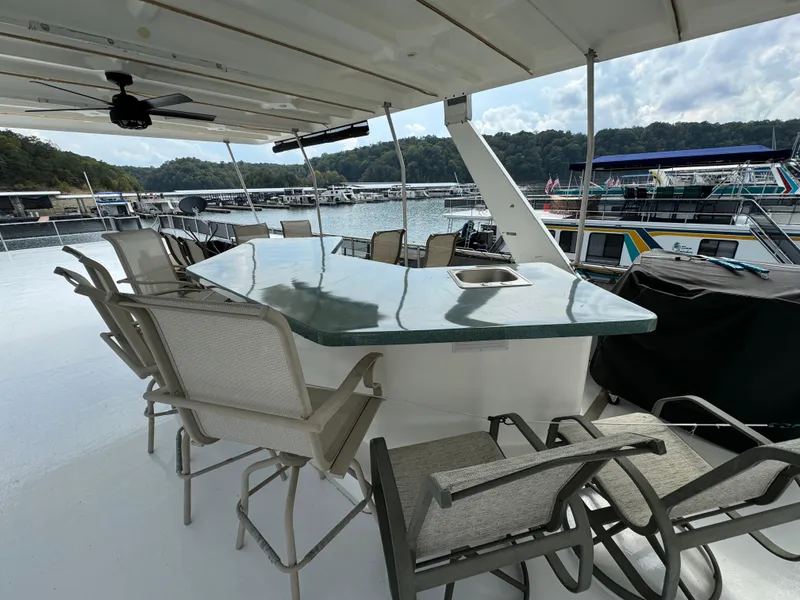 Slide: The Image of Outdoor seating area on a 1999 Sumerset 16 X 80 houseboat, featuring a bar and chairs. - 6