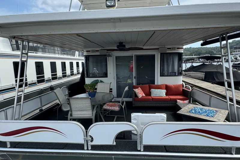 Slide: The Image of 1999 Sumerset 16 X 80 houseboat with outdoor seating and table on deck. - 9