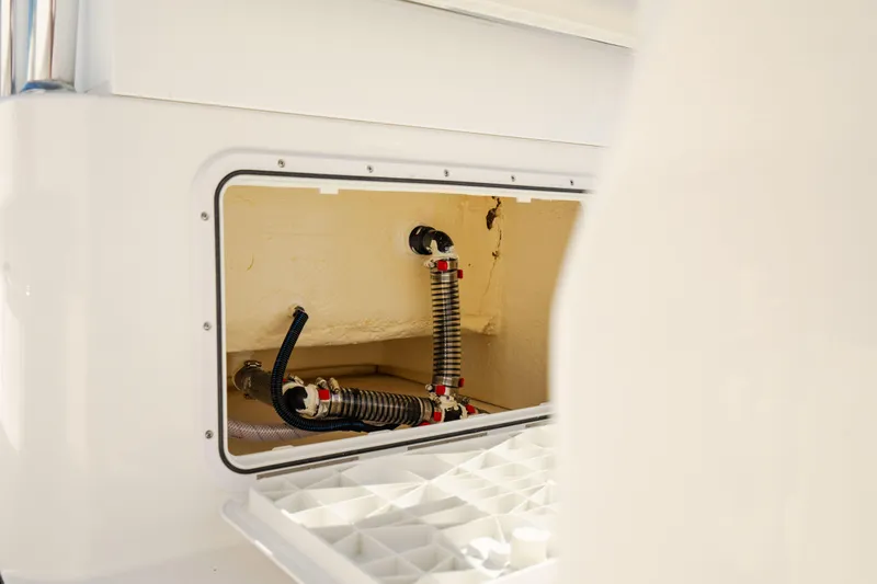 Slide: The Image of 2025 Edgewater 188CC boat interior showing storage compartment and hose connections. - 18
