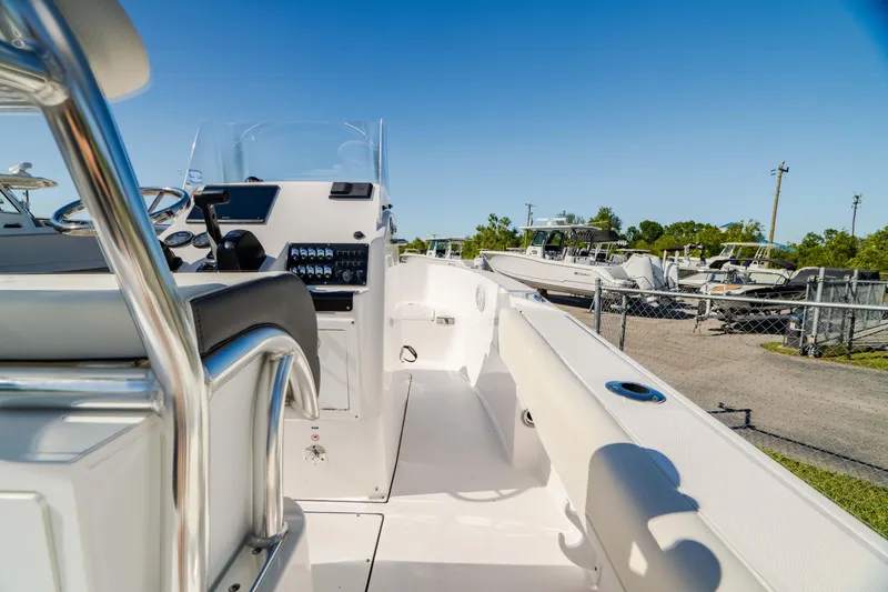 Slide: The Image of 2025 Edgewater 188CC boat interior with steering console and seating, under clear blue sky. - 4