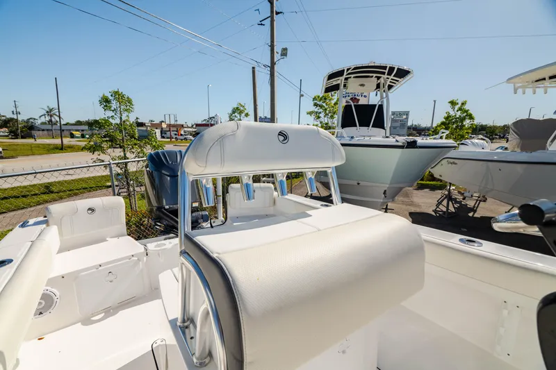 Slide: The Image of 2025 Edgewater 188CC boat interior with seating and console, parked outdoors. - 5