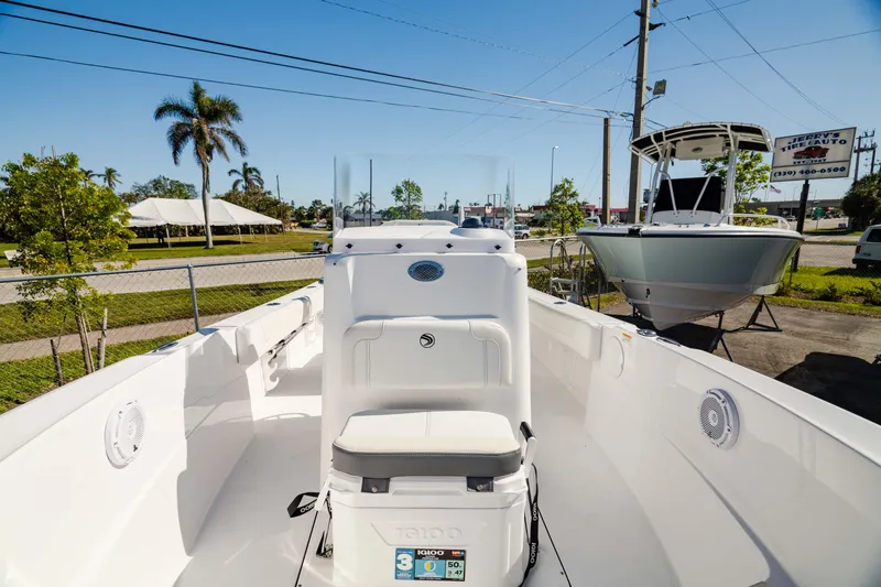 Slide: The Image of 2025 Edgewater 188CC boat interior with seating and console, parked outdoors. - 7