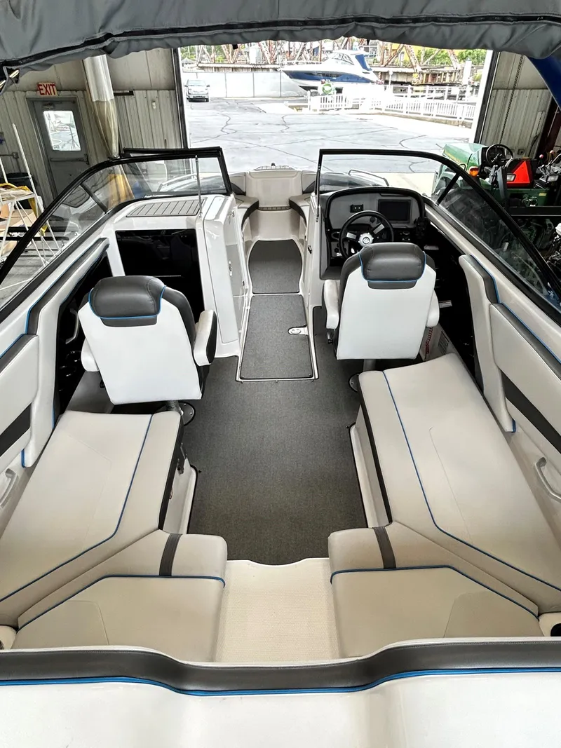 Slide: The Image of 2020 Yamaha AR 240 boat interior with seating and helm, docked in a marina. - 11