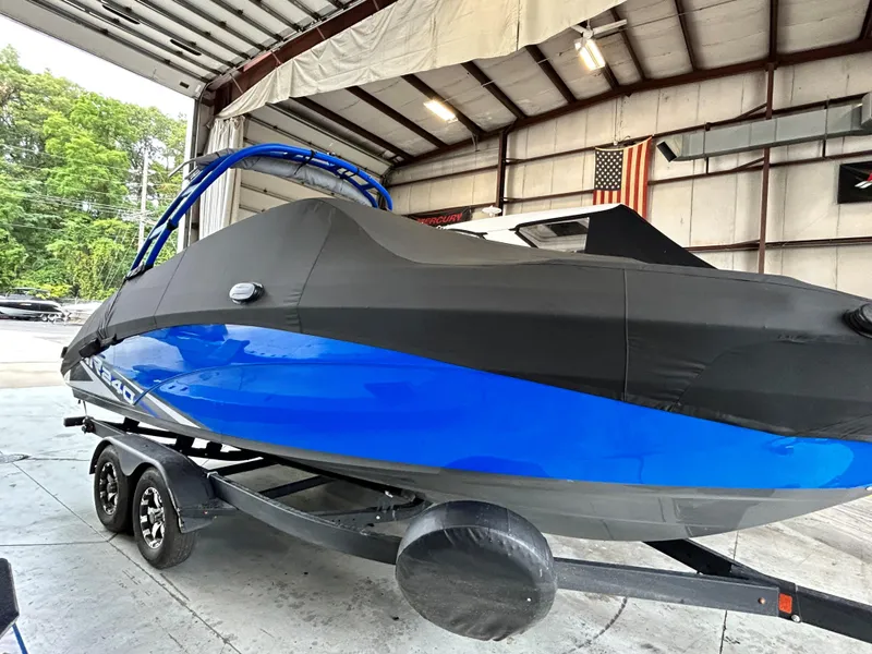 Slide: The Image of 2020 Yamaha AR 240 boat in storage, covered, on trailer in warehouse. - 2