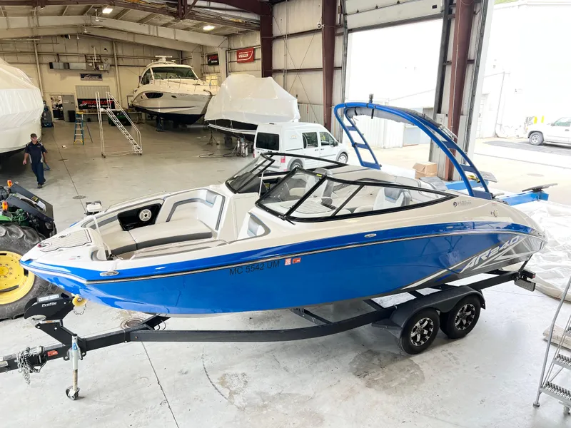 Slide: The Image of 2020 Yamaha AR 240 boat in a warehouse, blue and white design, on a trailer. - 3