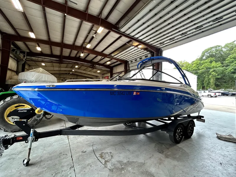 Slide: The Image of 2020 Yamaha AR 240 boat in a garage, blue exterior, on a trailer. - 4