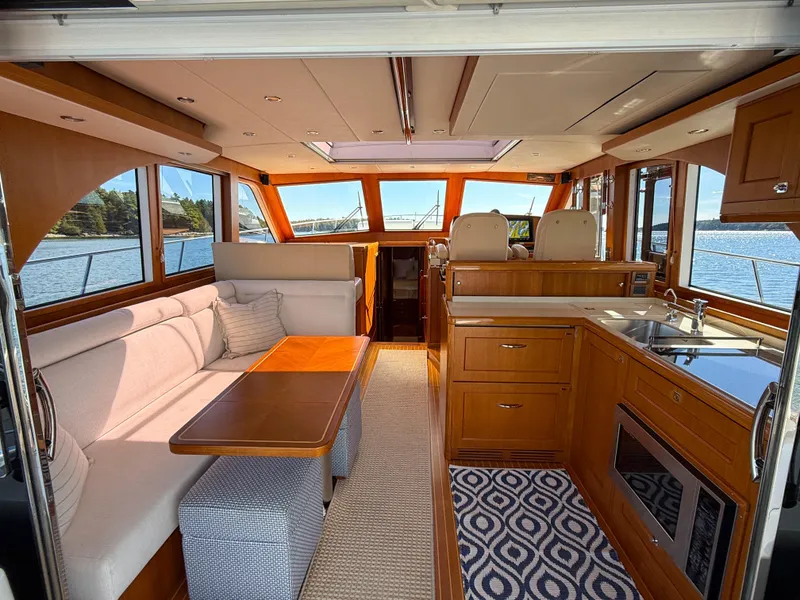 Slide: The Image of Luxurious 2014 Grand Banks 50 Eastbay SX yacht interior with elegant wood finishes and spacious seating. - 11