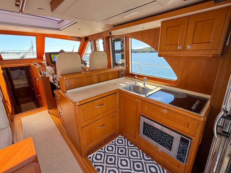 Slide: The Image of Luxurious 2014 Grand Banks 50 Eastbay SX yacht interior with modern kitchen and scenic water view. - 13