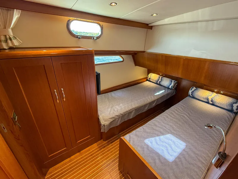 Slide: The Image of 2014 Grand Banks 50 Eastbay SX cabin with twin beds and wooden interior. - 23