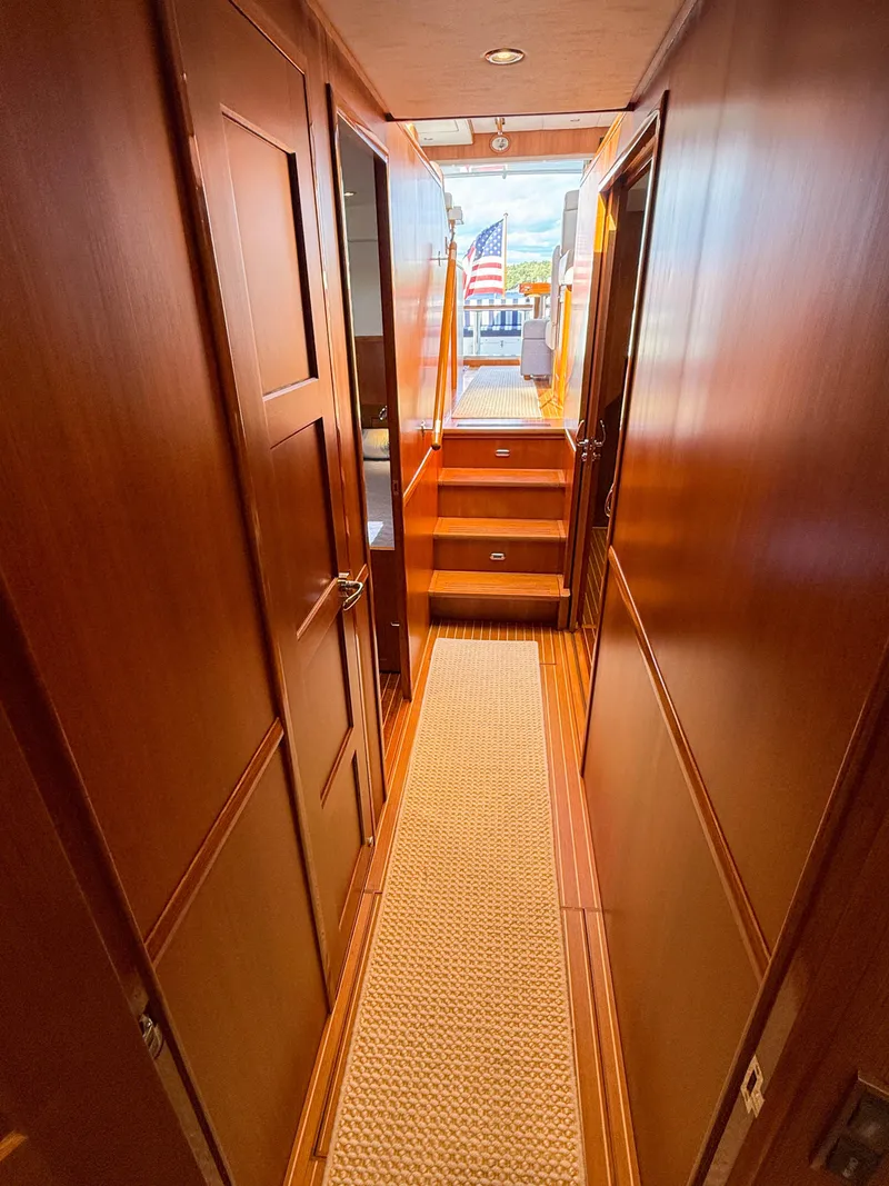 Slide: The Image of 2014 Grand Banks 50 Eastbay SX yacht interior hallway with wooden paneling and carpet. - 32