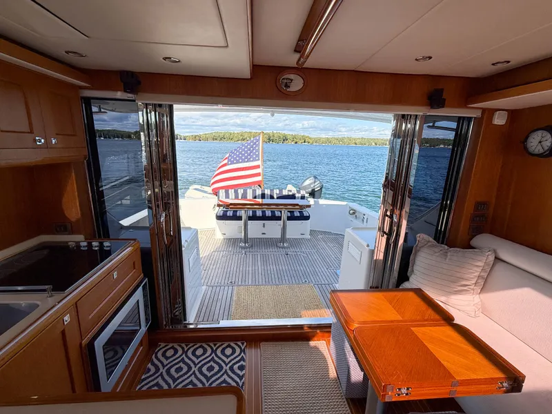 Slide: The Image of Interior view of 2014 Grand Banks 50 Eastbay SX yacht with open deck and American flag. - 35