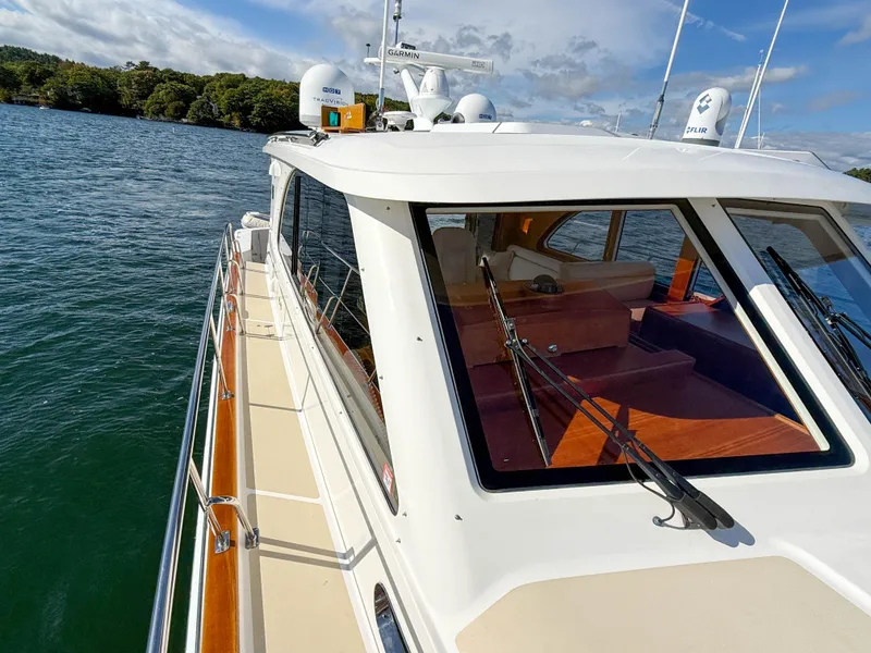 Slide: The Image of 2014 Grand Banks 50 Eastbay SX yacht on water, showcasing sleek design and spacious deck. - 47