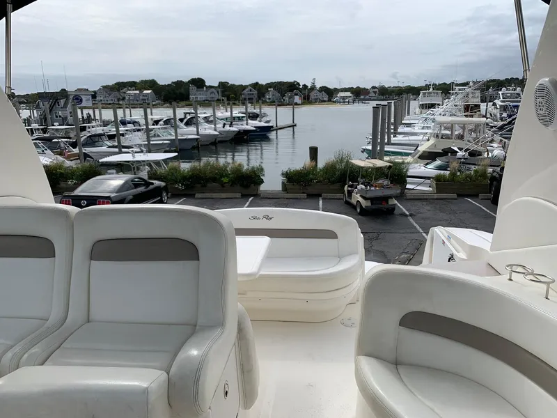 Slide: The Image of 2004 Sea Ray 320 Sundancer at marina, featuring spacious seating and scenic waterfront view. - 11