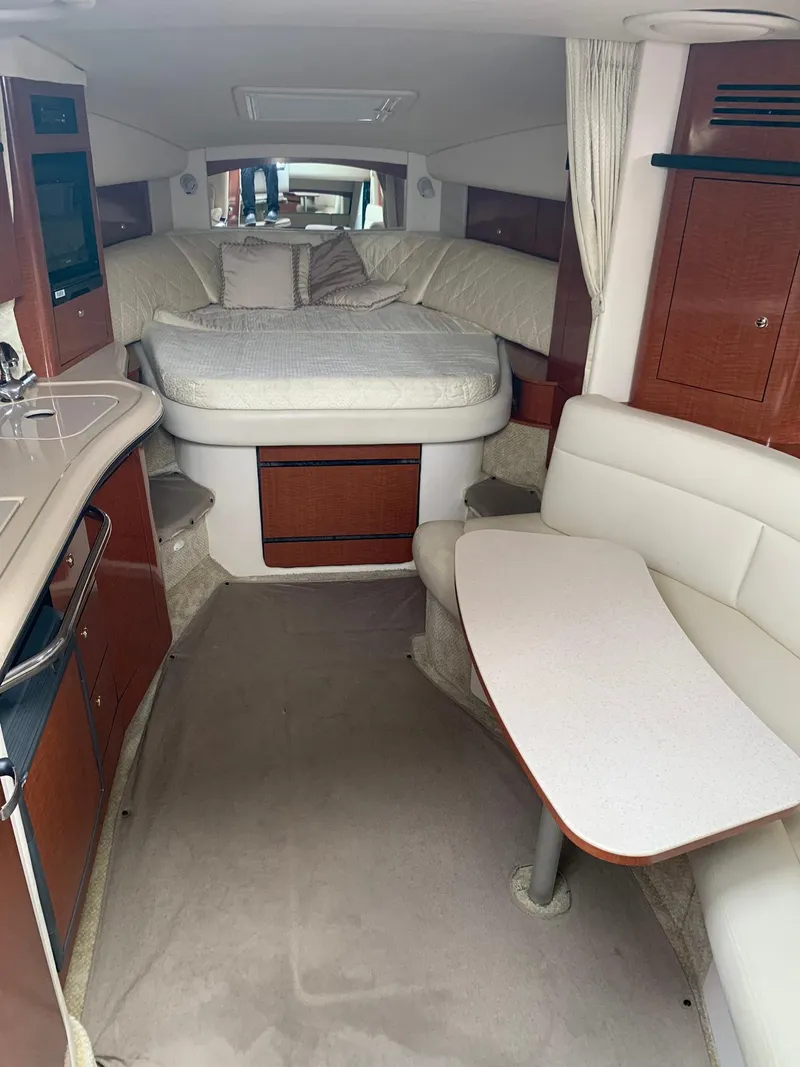 Slide: The Image of Interior of 2004 Sea Ray 320 Sundancer with bed, seating, and kitchenette. - 12