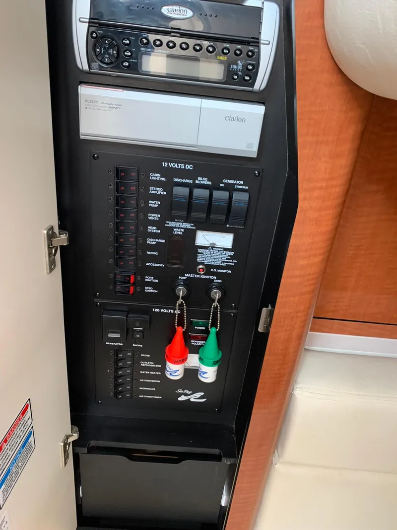 Slide: The Image of Control panel of a 2004 Sea Ray 320 Sundancer boat, featuring switches and stereo system. - 15