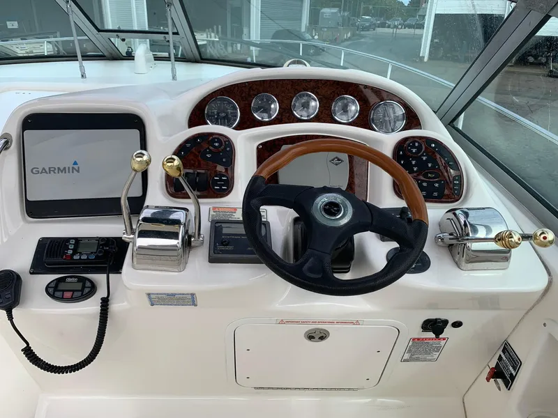 Slide: The Image of 2004 Sea Ray 320 Sundancer helm with Garmin navigation and wood-accented controls. - 7