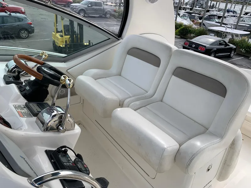 Slide: The Image of 2004 Sea Ray 320 Sundancer helm with dual white seats and steering wheel. - 8
