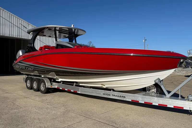 Slide: The Image of 2019 Mystic Powerboats M3800 in red on a trailer, parked outdoors. - 12