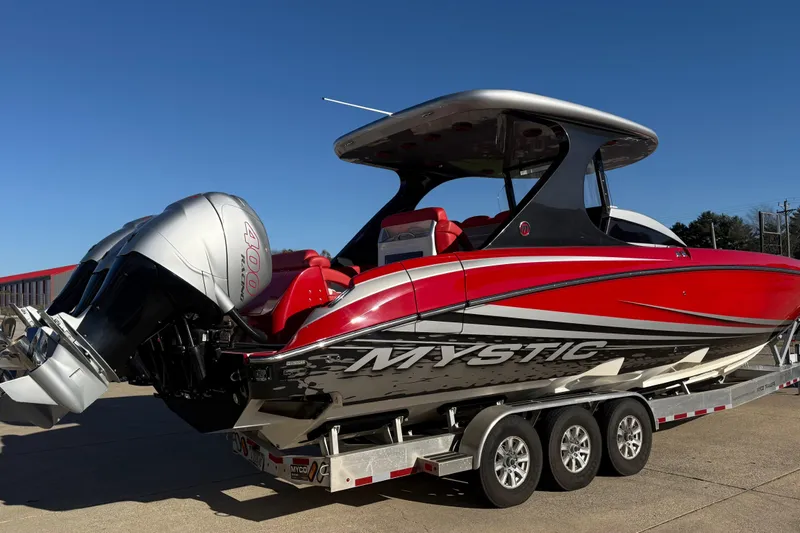 Slide: The Image of 2019 Mystic Powerboats M3800 with triple outboard engines on a trailer. - 13