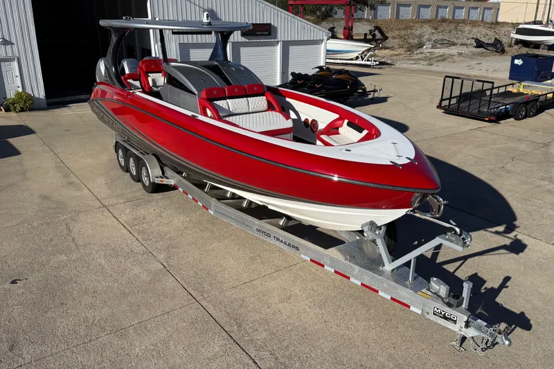 Slide: The Image of 2019 Mystic Powerboats M3800 in red and white on a trailer, parked outdoors. - 14
