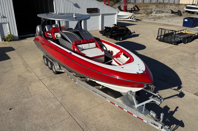 Slide: The Image of 2019 Mystic Powerboats M3800 in red and white on a trailer, parked outdoors. - 15