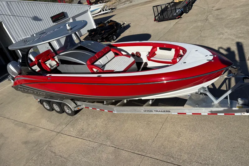 Slide: The Image of 2019 Mystic Powerboats M3800 in red and white on a trailer, parked outdoors. - 16