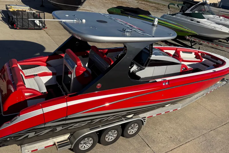 Slide: The Image of 2019 Mystic Powerboats M3800, red and white, on trailer, sleek design, luxury seating. - 19