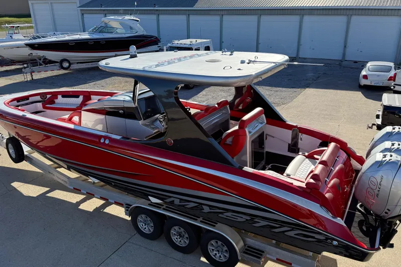 Slide: The Image of 2019 Mystic Powerboats M3800, red and black, on trailer in marina setting. - 23