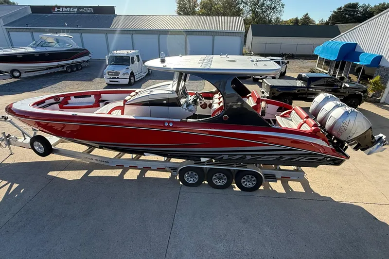 Slide: The Image of 2019 Mystic Powerboats M3800 in red on a trailer, parked outdoors. - 24
