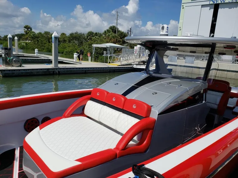 Slide: The Image of 2019 Mystic Powerboats M3800 with red and white seating at a marina. - 3
