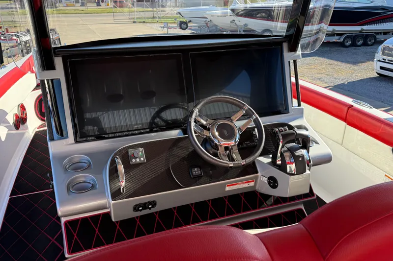 Slide: The Image of 2019 Mystic Powerboats M3800 cockpit with modern steering and controls, featuring red and black accents. - 32