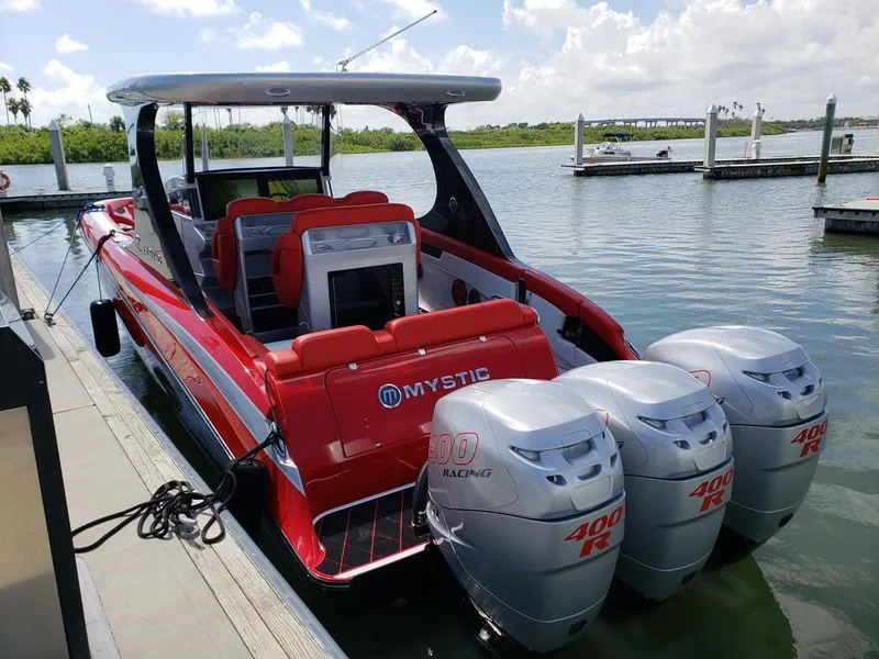Slide: The Image of 2019 Mystic Powerboats M3800 with triple 400R engines docked by the water. - 7