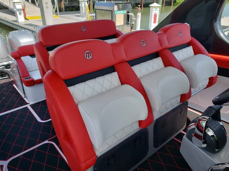 Slide: The Image of Red and white seating on 2019 Mystic Powerboats M3800, featuring quilted design and logo. - 8