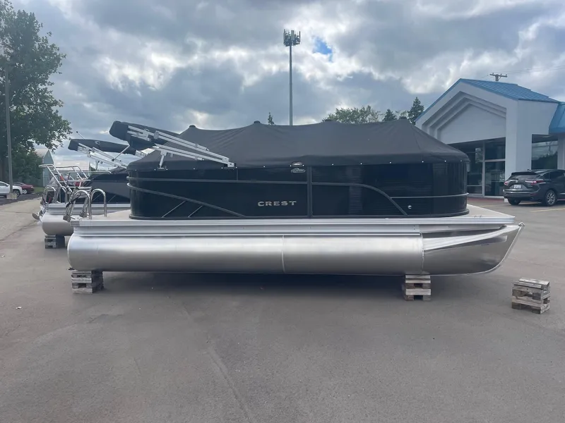Slide: The Image of 2024 Crest 200SLC CLASSIC LX pontoon boat with black cover, parked outdoors. - 4