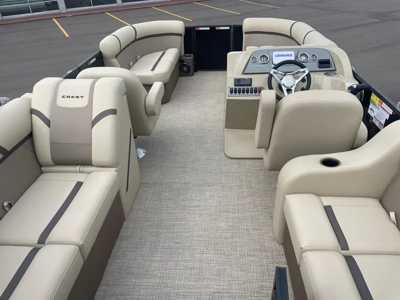 Slide: The Image of 2024 Crest 200SLC CLASSIC LX pontoon boat interior with beige seating and modern dashboard. - 7
