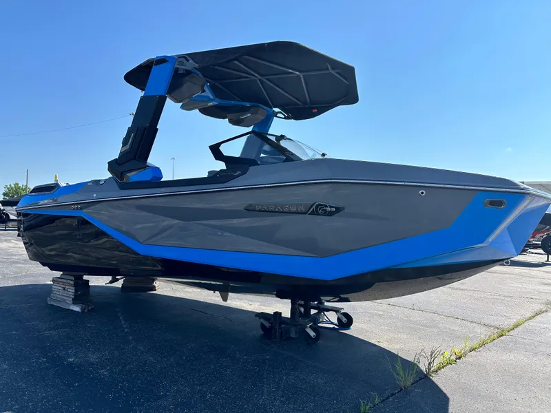 Slide: The Image of 2025 Nautique G23 Paragon boat with sleek design and blue accents, parked outdoors. - 11