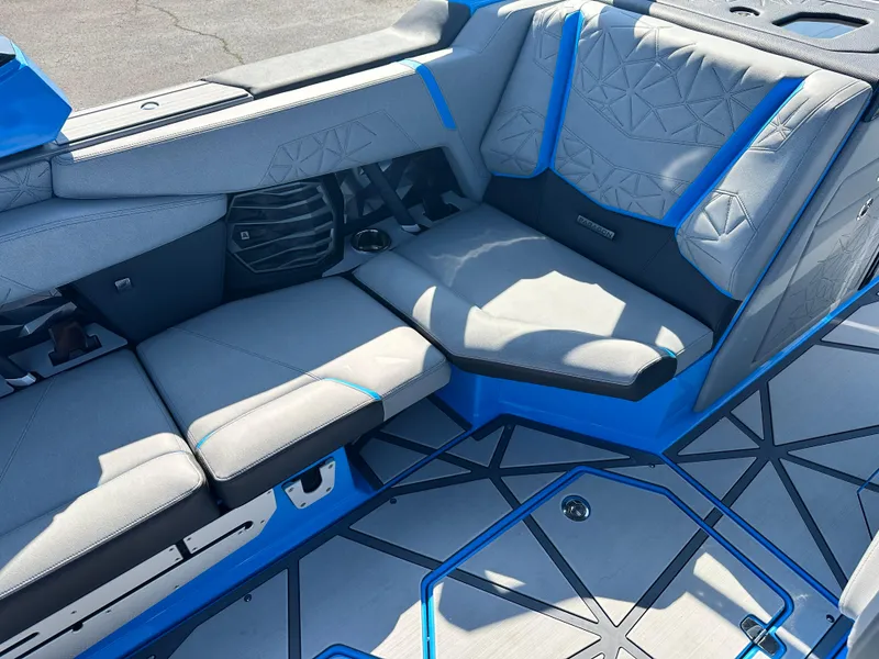 Slide: The Image of 2025 Nautique G23 Paragon interior with gray and blue seating, geometric floor design. - 15