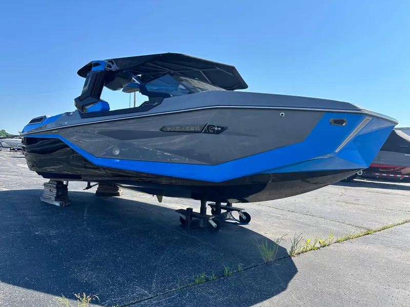 Slide: The Image of 2025 Nautique G23 Paragon boat with sleek blue and black design on display outdoors. - 6