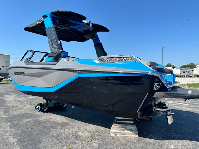 Slide: The Image of 2025 Nautique G23 Paragon boat, blue and gray, parked on pavement under clear sky. - 9