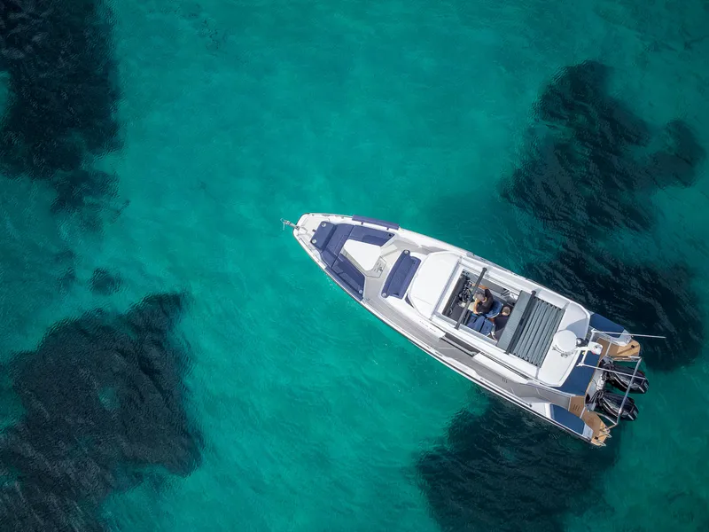Slide: The Image of Aerial view of 2025 Axopar 29 XC Cross Cabin on clear turquoise water. - 4