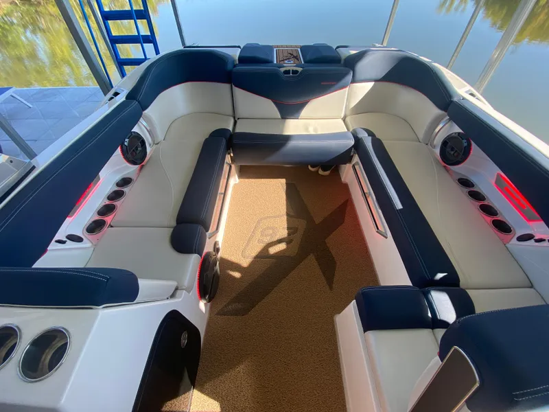 Slide: The Image of 2018 MasterCraft X26 boat interior with plush seating and cup holders. - 19