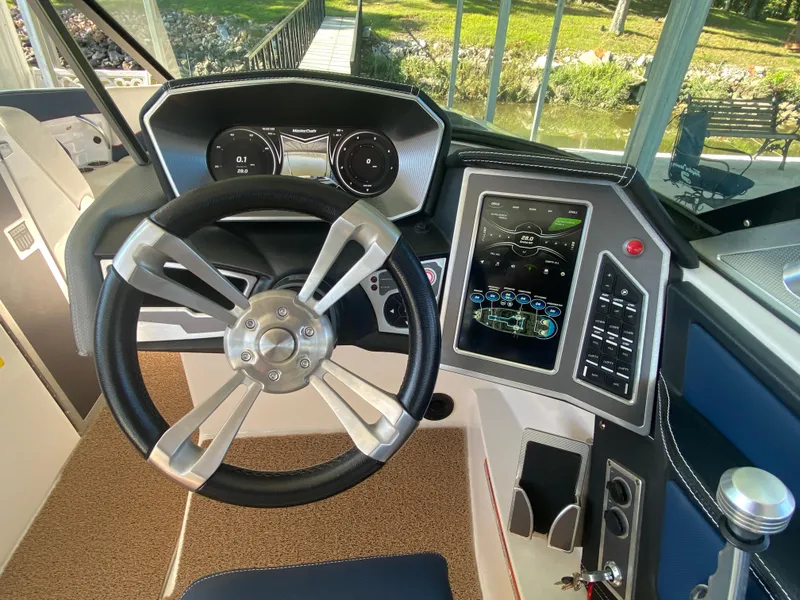 Slide: The Image of 2018 MasterCraft X26 boat dashboard with steering wheel and digital controls. - 31