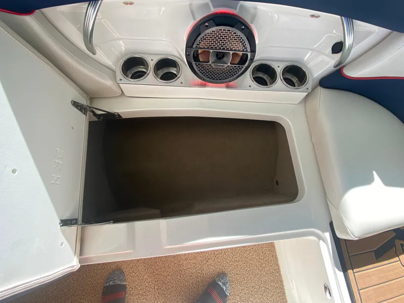 Slide: The Image of 2018 MasterCraft X26 boat storage compartment with speaker and cup holders. - 38