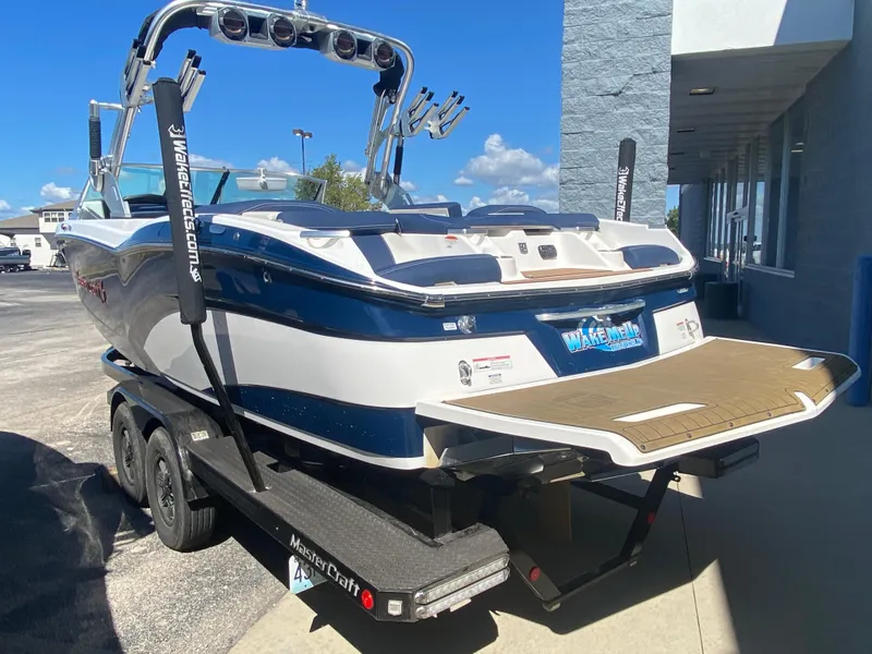 Slide: The Image of 2018 MasterCraft X26 boat on trailer, parked outdoors, sunny day. - 45