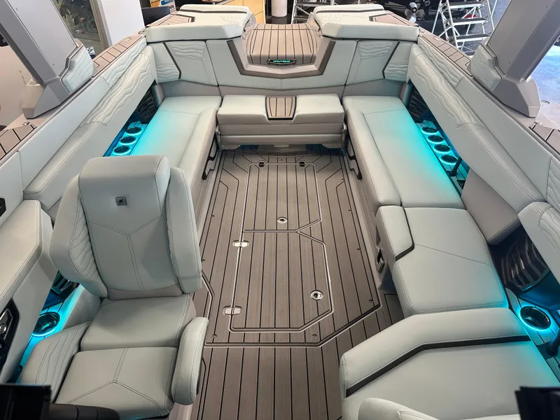 Slide: The Image of 2025 Nautique G25 boat interior with sleek seating and ambient blue lighting. - 10